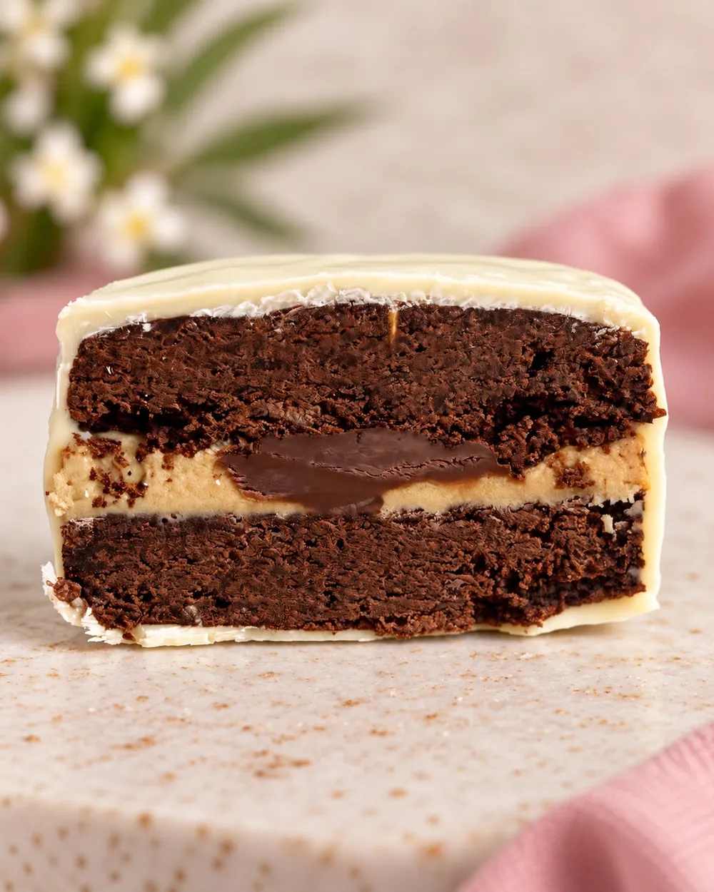 Alfajor de chocolate, café y Nutella cortado al medio, con cobertura de chocolate blanco